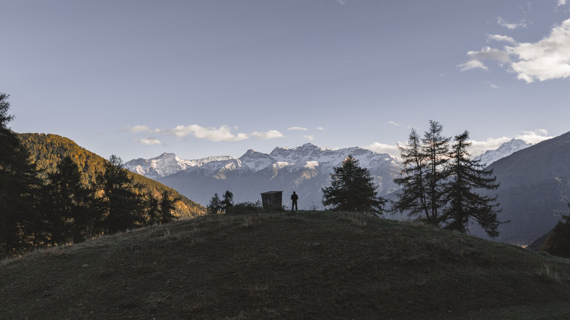 Fotograf als Silhouette auf einem Hügel vor Bergpanorama — René Paschold Landschaftsfotografie